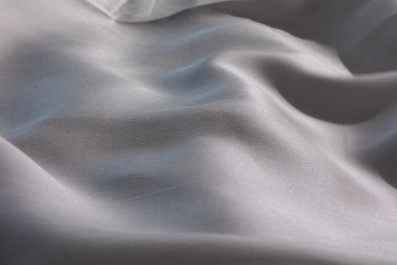 Close-up of draped white fabric with soft folds and a smooth texture. #color_silver