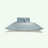 A light green-gray bedding set, including a large pillowcase and folded sheets, floating against a solid off-white background. #color_aloe
