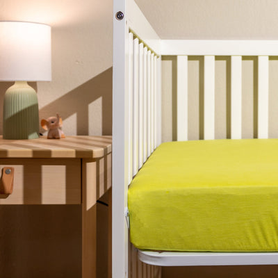 a white crib with yellow crib sheets||Tree Frog