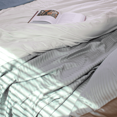 grey stripe eucalyptus sheets on a bed with a white comforter made from you guessed it eucalyptus ||Light Gray Stripes #color_light-gray-stripes